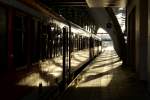 Schwarze Umrisse,ein roter Triebwagen und goldenes Licht am Tag der ...