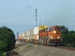 Burlington Nothern and Santa Fe BNSF Vier BNSF Dash-9 bringen einen Twin-Stack Containerzug durch Rose Hill, Kansas am 21.07.2009.