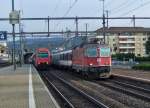 re-4-4-ii-re-420 SBB: Stehend die Eine, fahrend der Andere. W�hrend die S3 nach Wetzikon mit der Re 450 043 'Rorbas' ihre Reisenden und Pendler einsteigen l�sst, donnert die Re 4/4' 11237 mit einem IR vorbei.