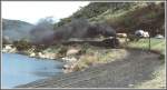 Schmalspurdampf Die Dampflok mit ihrem langen Kohlenzug zum Hafen von Imbituba �berholt hier bei Lagoa eine schleichende Autokolonne auf der parallelen BR 101.(Archiv 04/1981)