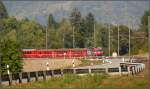 Luftseilbahnen L�ngs der Kantonsstrasse zwischen Rh�z�ns und Rothenbrunnen erscheint der RE1141 mit Ge 4/4 III 646 auf der Fahrt von Chur nach St.Moritz. Zur gleichen Zeit �berquert die Luftseilbahn Rh�z�ns - Feldis die Rheinschlucht. Eine der beiden runden Kabinen ist links �ber dem letzten Fahrleitungsmasten zu erkennen. (01.10.2009)