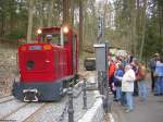 sonstiges Die Bad Schwalbacher Kurbahn f�hrt an jedem Sonn- und Feiertag von April bis Oktober auf der Bahnstrecke der ehemaligen Moorbahn im Kurpark von Bad Schwalbach. Die Strecke mit einer Spurweite von 600 mm f�hrt von der Entladestelle oberhalb des Moorbadehauses �ber 1,6 km bis zur Moorgrube 10. Im Personenverkehr werden 1,3 km Strecke befahren: Anfangspunkt ist die Station „Moorbadehaus“ (Bild), die am tiefsten Punkt der Strecke liegt. Endstation ist die Station „Moorgruben“ an der Moorgrube 7. Die beiden Stationen mit Umsetzgleisen wurden f�r den Personenbetrieb neu geschaffen. Die auf dieser Aufnahme vom 17.04.2006 zu sehende Lok mit der Betriebsnummer 2 (SCH�MA Baujahr 1988) hatte urspr�nglich eine Spurweite von 900 mm und war auf der franz�sischen Seite der Kanaltunnelbaustelle im Einsatz. Die Lok wurde Ende 2002 vom Bad Schwalbacher Kurbahn-Verein angekauft und bei SCH�MA auf 600 mm Spurweite umgespurt.