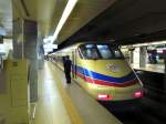 tokyo-der-keisei-konzern Keisei-Konzern, AE (Airport Express) Serie 100: Zug Nr.3 mit Endwagen AE 121 wartet in der Endstation Internationaler Flughafen Tokyo-Narita. Der Schaffner �berwacht die T�ren, ganz rechts aussen erkennt man einen Zug der JR (1067mm-Spur), der auf einer eigenen Strecke den Flughafen erreicht (der Keisei-Konzern hat 1435mm-Spur). 22.November 2009. 