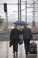  Dienstende   Zugbegleiter und Schaffnerin eines in Prag endenden Rx verlassen das Bahnhofsgelände über den Wegeübergang.