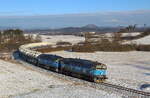 Pn 53955 mit Brillendoppel 753 772 und 753 758 schlängelt sich mit dem vollen Zwiebelwagenzug durch die leicht an gezuckerte Winterlandschaft des Rollberg-Hügellandes. Aufgenommen wurde der Zug, der aus Beroun kommt und nach Brniste geht, am 27.02.2023.