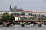Ein Städtefoto mit Straßenbahn: Im Vordergrund mit Tram die Palackého most, darüber die Prager Burg.