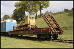 Eine Raupe als Ladegut und ein Flachwagen mit eigener angebauter Rampe stand am  14.10.2016 im Bahnhof Voronenko in den ukrainischen Karpaten.