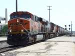 Eine 3er Traktion BNSF Dieselloks zieht einen 110 Wagen Getreidezug durch Newton, Kansas am 09.07.2009.