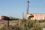 Ein Intermodal Zug, gezogen von den BNSF Loks # 6710 (GE ES44C4), 4183 (GE C44-9W) und 7886 (GE ES44DC), passiert das berhmte Hinweisschild des Jackrabbit Trading Post in Joseph City / Arizona  HERE IT IS . USA, September 2011.