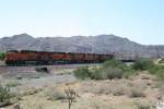 BNSF Lok # 6742 (ES44C4), # 7423 (ES44DC), # 7254 (ES44DC), # 5237 (C44-9W) und eine Weitere ziehen einen Containerzug durch Arizona.