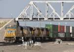 5.7.2012 Cheyenne, WY. Union Pacific 4488, (SD70M), 5186 (SD70M), 7770 (ES44AC)& eine unbekannte bei der Einfahrt ins UP Yard mit einem Containerzug. Die Brcke im Hintergrund gehrt der BNSF.