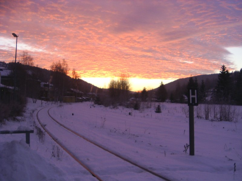 Winterlicher Sonnenaufgang zwischen den erzgebirgisch-vogtlndischen Bergen im November 2007, Bahnhof Klingenthal.