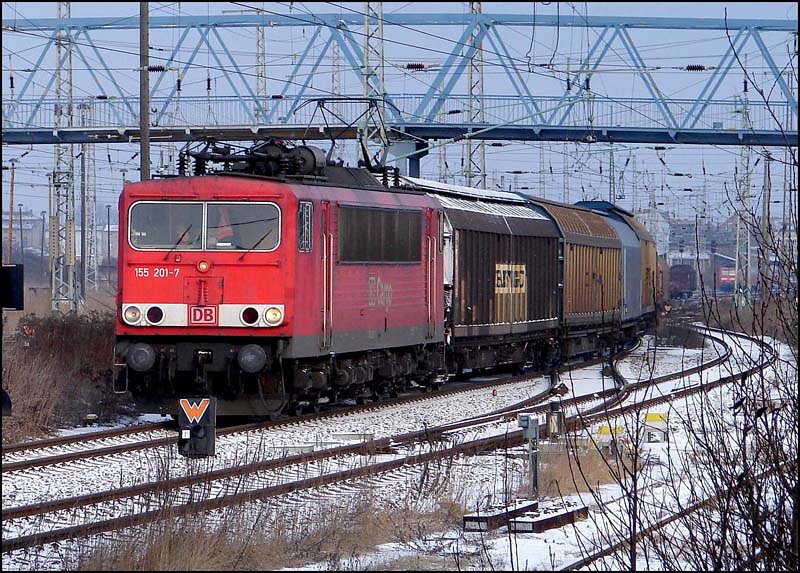 Winterzeit - 155 201-7 ist mit seinem Gterzug unterwegs zum Fhrhafen Mukran. (Stralsund am 11.03.06) 


