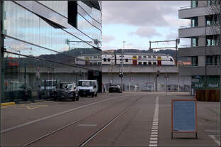 Der Gegenzug hat sich unauffällig ins Bild geschmuggelt -    Ein RABe 511 S-Bahn-Triebzug kurz nach der Abfahrt aus dem Bahnhof Zürich Hardbrücke passiert das dortige Maag-Areal.