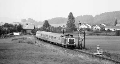 211 034 unterwegs von Bayerisch Eisenstein nach Plattling bei Gotteszell (August 1983).