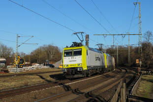 185 541-0 und eine unerkannt gebliebene Schwestermaschine passieren den BÜ Heideäcker am ehemaligen Bw Hanau.