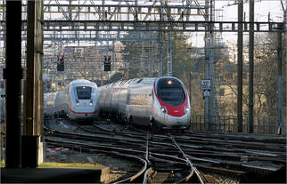 Der Bahnhof Bern -     Draußen auf dem Lorraineviadukt taucht rechts neben dem ICE ein Hochgeschwindigkeitszug der Baureihe RABe 503 auf und fährt langsam mit einer Linksdrehung des