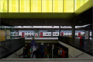 Unter leuchtendem Gelb -     - befindet sich der Abgang zur Bahnsteigunterführung im Bahnhof Zürich-Oerlikon.