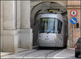 Enge Durchfahrt -     Eine moderne Niederflurstraßenbahn unter dem Tor nahe dem Malostranské náměstí in Prag.