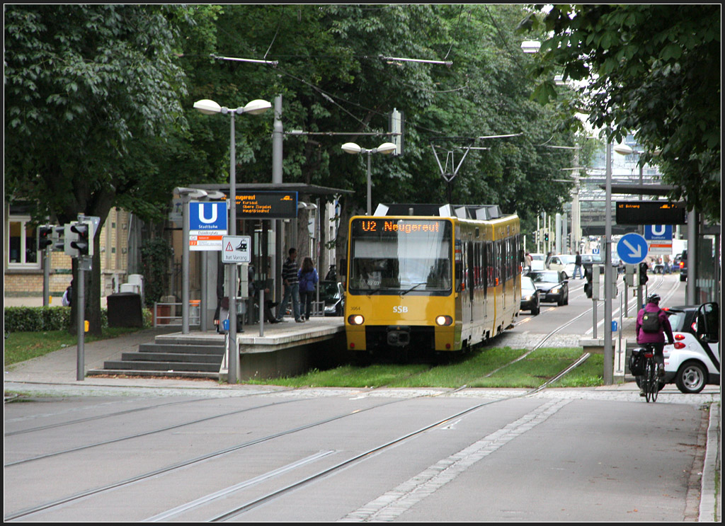 . Abgesenkt - 

Städtebaulich schwierig unterzubringen waren die Hochbahnsteige an der Haltestelle Daimlerplatz der Linie U2 in Stuttgart-Bad Cannstatt. Um die für die Bahnsteige nicht zu hoch über den Platz aufragen zu lassen, wurden zusätzlich die Gleise etwas abgesenkt. Die Bahnsteige selbst wurden in das Oval des Platzes geschickt integriert. 

08.06.2011 (M)