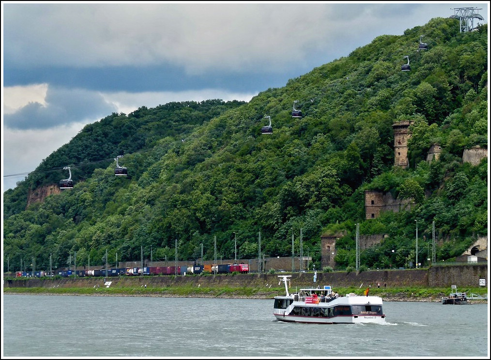 - Am Rhein - In Koblenz bringt die Rheinseilbahn am 23.06.2011 die BuGa Besucher zur Festung Ehrenbreitstein und zurck, whrend unten auf der rechten Rheinstrecke ein Gterzug vorbeifhrt. (Jeanny)