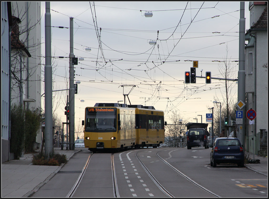 . Einfahrt nach Stammheim - 

Ein Stadtbahnzug der Linie U15 verlässt die Haltestelle  Heutingsheimer Straße  und fährt in die Ortsdurchfahrt von Stuttgart-Stammheim ein. 

11.12.2011 (M)