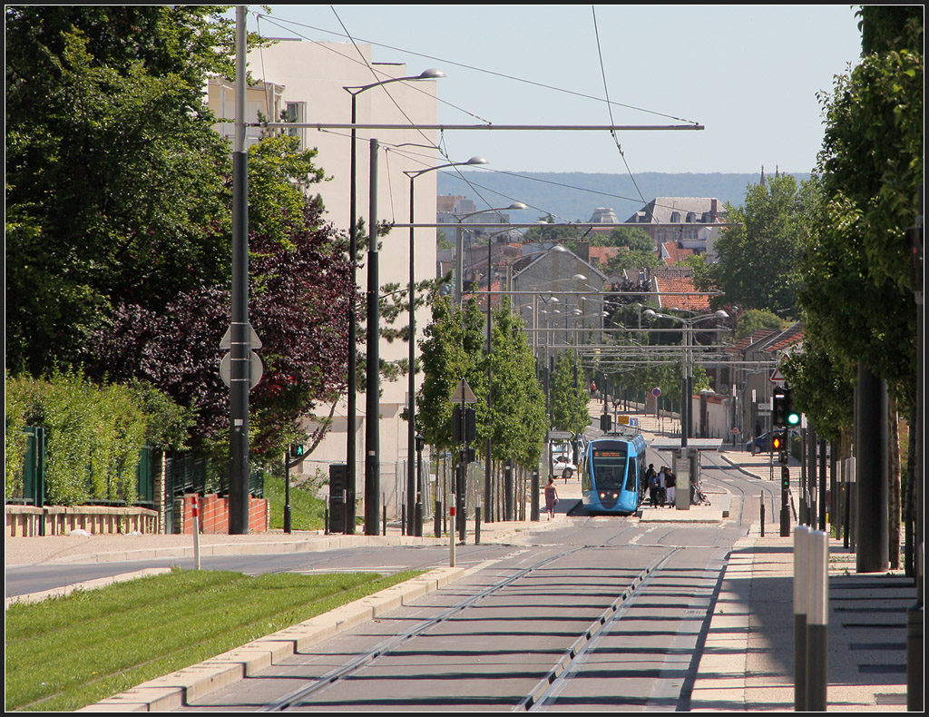 . Reims, Rue Docteur Albert Schweizer - Diese Strae wird weitgehend ohne eigenen Bahnkrper durchfahen. Im Hintergrund die Haltestelle  De Fermat  mit Wagen 106 in Fahrtrichtung Norden. 23.07.2012 (Matthias)