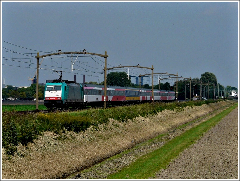 - Unterwegs in Noord-Brabant - Die TRAXX 2802 rauscht am 03.09.2011 mit dem IC Amsterdam-Antwerpen unter den alten Oberleitungsmasten durch Zevenbergen. (Hans)