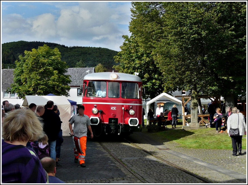 - Zu Besuch bei der Oleftalbahn - In Olef befindet sich die deutschlandweit einmalige Streckensituation der �berfahrt der normalspurigen Bahn mitten �ber den Dorfplatz, wo am 28.08.2011 dichtes Gedr�nge herrschte, da an diesem Tag ein Handwerker- und Hobbymarkt dort stattfand. F�r die Mitarbeiter der Oleftalbahn ist diese Ortsdurchfahrt der anstrengendste Streckenabschnitt. (Hans) 