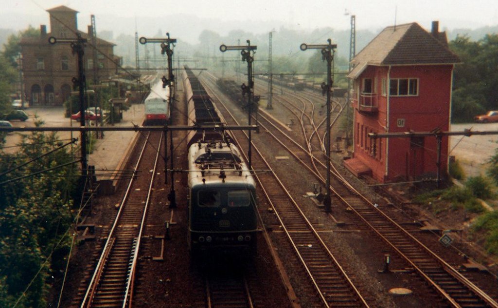 05.05.1982 - Historisches Foto (verzeihung f�r die schlechte Qualit�t) vom HBF Hattingen Ruhr, mit einem Erzzug (36 Wagen) in Richtung Henrichsh�tte, gezogen von einer BR 151 ... 
Nebenan eine Rhein Ruhr S-Bahn mit der BR 111 111 - 1  ...
Rechts neben dem damals noch vorhandenem Stellwerk befand sich einst das BW Hattingen Ruhr.
Heute f�hrt die S-Bahn auf der gegen�berliegenden Seite des EGs und die Linie wurde verl�ngert bis Hattingen Mitte.  Auch die Henrichsh�tte ist Geschichte. Die Hoch�fen wurden im Januar 1988 stillgelegt, das Stahlwerk lief noch bis Mai 1992. Torpedoz�ge mit bis zu vier 18 Achser Torpedopfannen ersetzten die Koks und Erzz�ge... Gezogen wurden diese Torpedoz�ge von den Baureihen; 261, 216, 218, 140, 243, einmal sogar eine Orientrote 120 und eine TEE farbene 103 ... (!)
Ich verb�rge mich f�r diese Aussage ...
Eine 151 oder 150 war niemals vor einem Torpedozug zu sehen, ...
Auch die Stra�enbr�cke (Neubau 2010) und die alte Signalanlagen existieren nicht mehr...
Nach 1992 wurden noch Bleche veredelt und Restauftr�ge im Walzwerk erledigt.
Ab Mitte der 1990er Jahre dann reaktivierte eine LKW Spedition einen winzigen Teil der einst riesigen Gleisanlagen, welche dann bis etwa zum Jahr 2000 erweitert wurden...
Gefahren werden heute Stahlcoils in geschlossenen Wagen, Bleche in Flachwagen und Schrott f�r den Schrottplatz B�tzel in Blankenstein wozu auch ausgemusterte G�terwagen geh�ren...

Selbstverst�ndlich sei auf den Schienenbus der Ruhrtalbahn und den Dampfzug hingewiesen welche ebenfalls hier regelm�ssig Halt machen ...

Ich bitte die schlechte Quallit�t zu entschuldigen, und hoffe die Einmaligkeit dieses Bildes ist es Wert dennoch gezeigt zu werden.

