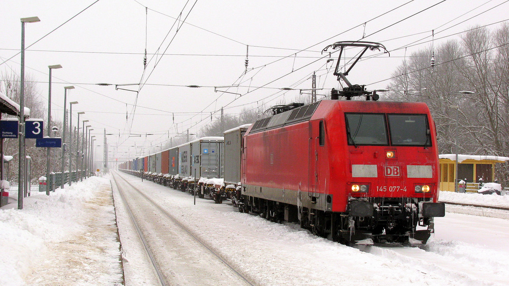 [1] Nachdem uns die Fe im Tiefschnee schon frierten, ging es mit dem Auto gemchlich weiter gen Baruther Bahnhof. Dort begegneten wir der 145 077-4 mit einem Containerzug, welcher nach einem Bremsdefekt dort abgestellt wurde. Heute (29.12.) nun wurde der Weg zur Lok erstmal frei geschippt, dann wurde sie rangesetzt und der Wagenmeister begann die Bremsen mit einem Hammer zu lsen.