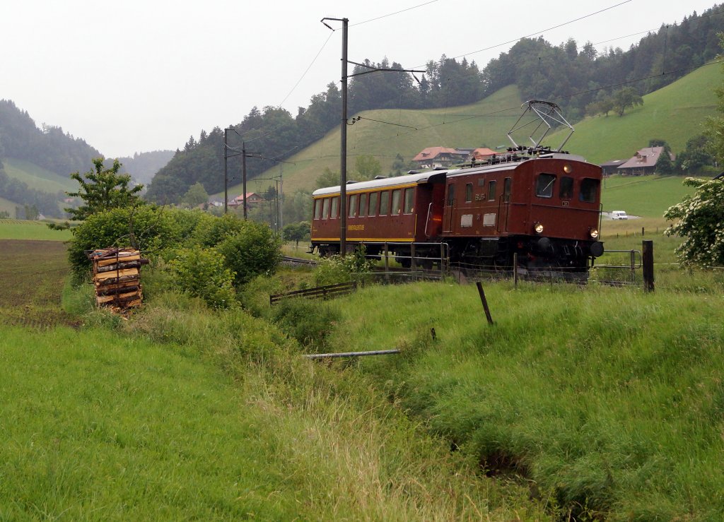 100 Jahre BLS: Durch den grossen Festrummel in Frutigen blieb die Anreise der Eisenbahnfreunde aus dem Emmental (Huttwil) eher unbemerkt. Ihre Reise führte ab Huttwil via Langenthal - Burgdorf - Hasle-Rüegsau - Konolfingen - Thun ins schöne  Bärner Oberland . Der interessante Extrazug, bestehend aus dem Te 2/3 31 und der Emmentalerstube, wurde trotz heftigen Niederschlägen am frühen Morgen des 29. Juni 2013 bei starker Bewölkung in der zum Zug passenden hügeligen Landschaft mit Bach und  Scheiterbeige  bei Walkringen im Bilde festgehalten.
Foto: Walter Ruetsch