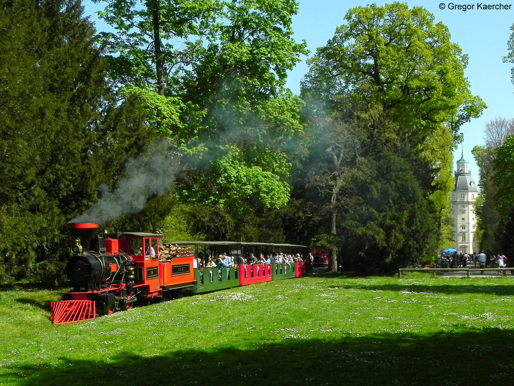 10.04.2011, Schlossgartenbahn Karlsruhe. Die Dampflok 21 Greif verlsst mir Ihrem Zug den Bahnhof. Rechts ist der Turm des Karlsruher Schloss zu sehen.