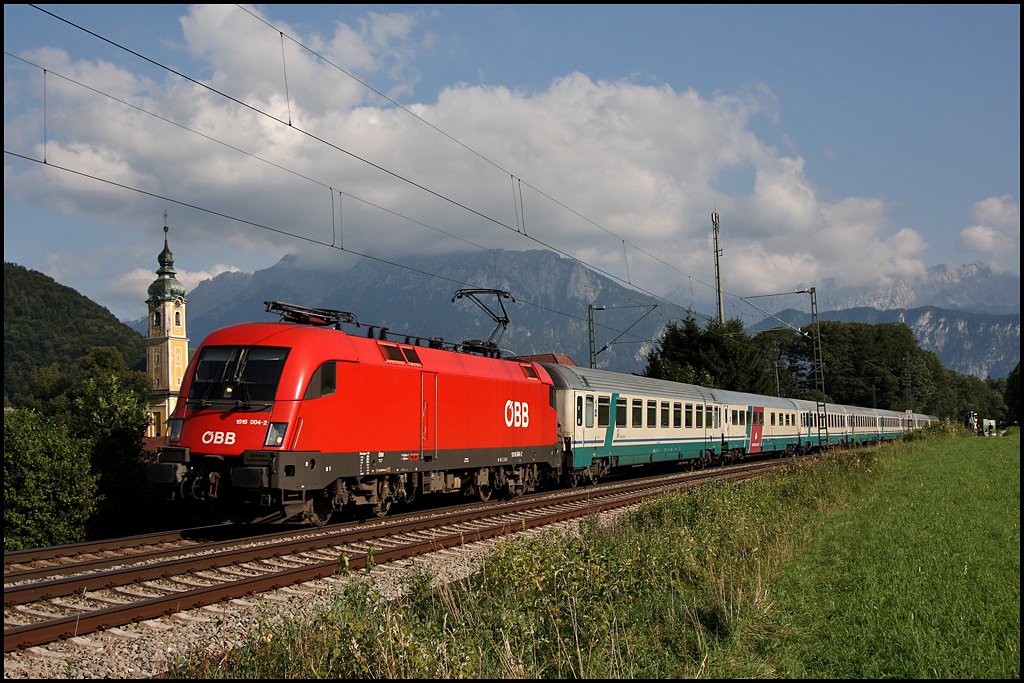 1016 004 ist ebenfalls im sauberen Betriebszustand und legt sich vor dem Kaisergebirge mit dem EC 84  MICHELANGELO  in die Kurve. Kloster Raisach am 05.08.2009.