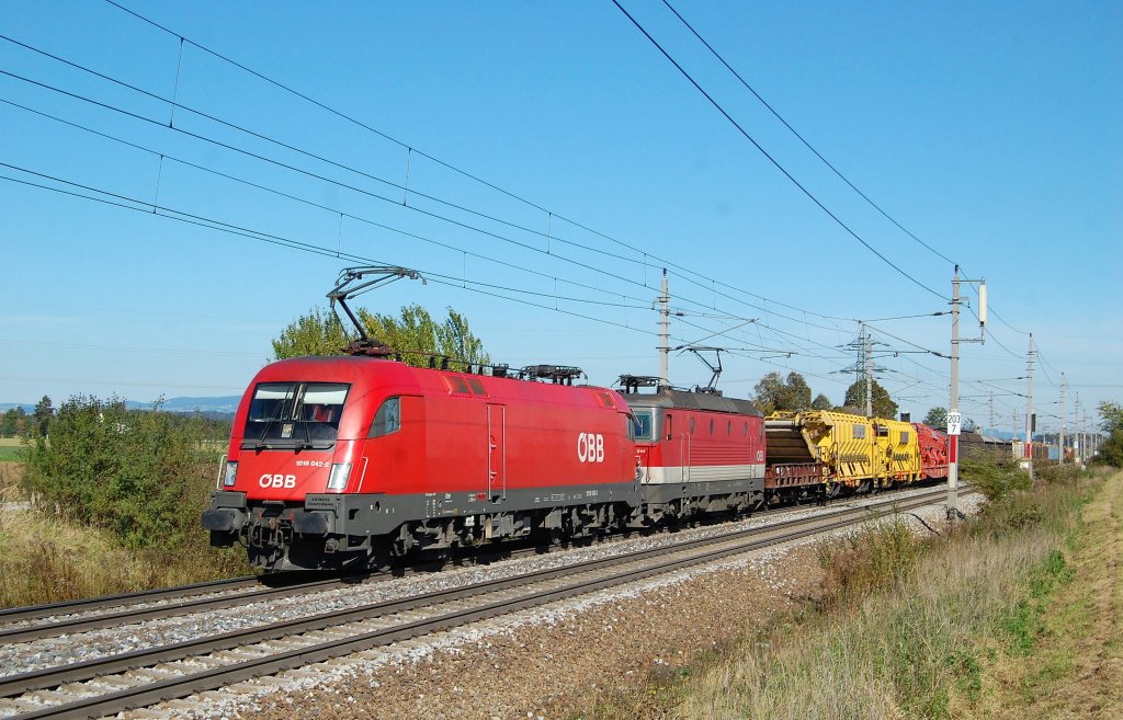 1016 042 und 1144 244 mit einem gemischten G�terzug am 15.10.2011
unterwegs nahe Marchtrenk.