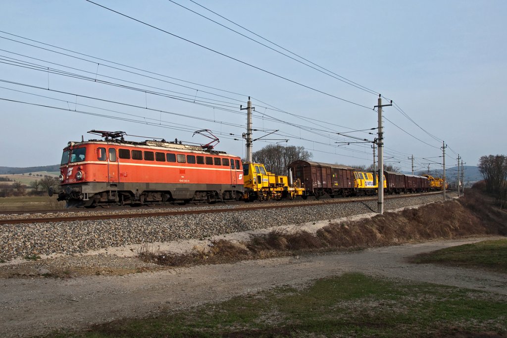 1042 033 fhrt mit einem Bauzug Richtung Westen. Die Aufnahme entstand kurz nach Bheimkirchen, am 25.03.2011.