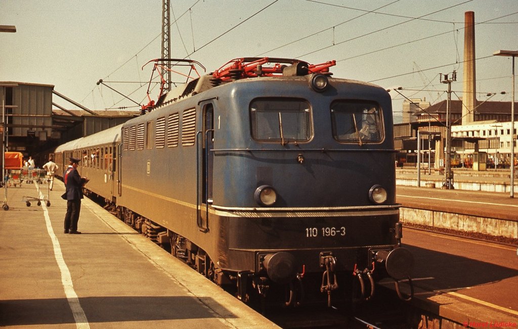 110 196-3 im Mai 1978 im Stuttgarter Hauptbahnhof. Der Zugführer füllt gerade den Bremszettel aus, den er gleich an den Lokführer übergeben wird. 