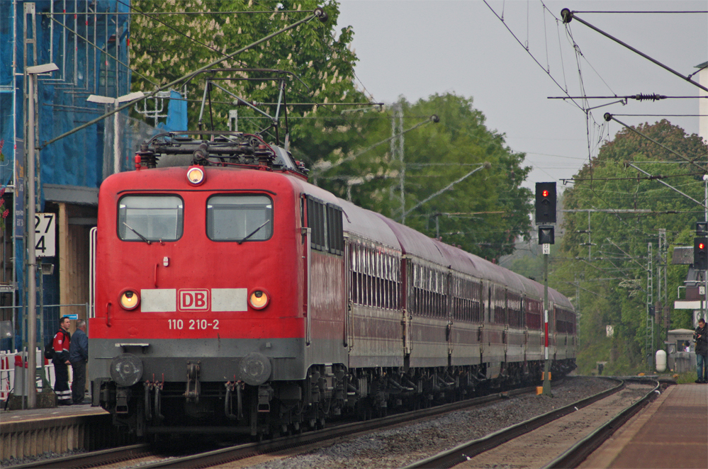 110 210-2 mit dem 20 Minuten Verspteten DZ13070 aus Emmerich nach Aachen und weiter nach Lourdes am Abend des 8.5.10 bei der Einfahrt in den Bahnhof Geilenkirchen