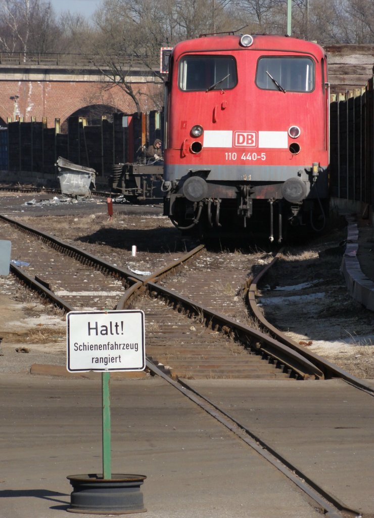 110 440-5 ein letzter Gru�. Auf dem Schrottplatz von Theo Steil in Eschweiler-Aue steht sie schon etwas gerupft und mu� zusehen, wie die Reste einer 143 hinter ihr mit dem Schneidbrenner zerschnitten werden. Aufgenommen 24.03.2011 durch den Zaun mit Zoom von der Phoenixstra�e aus.