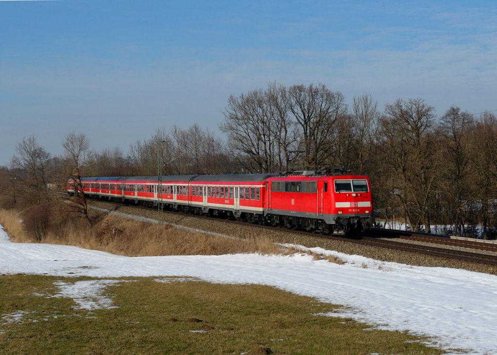 111 022 mit einem RE nach Salzburg am 21.02.2012 bei Hilperting.