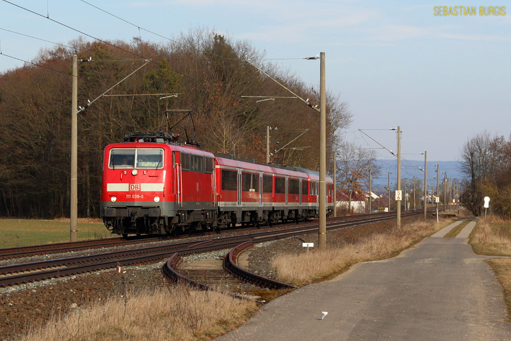 111 036-0 fhrt am 22.03.2013 mit ihrer Verstrker-RB von Bamberg nach Hafurt zwischen Drfleins und Oberhaid. Im Vordergrund ist der Gleisanschluss fr Trafotransporte zum nahen Umspannwerk zu sehen.