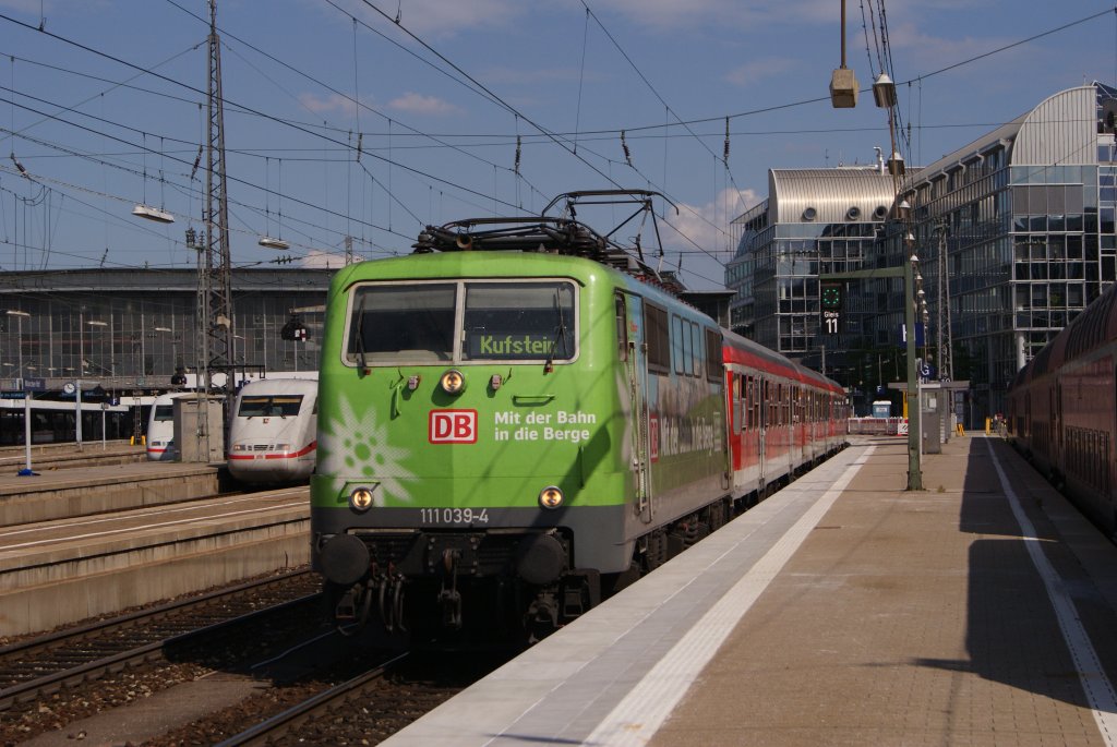 111 039-4  Mit der Bahn in die Berge  zieht am 27.07.2011 den RE 79077 nach Kufstein.Hier bei der Ausfahrt aus Mnchen Hbf