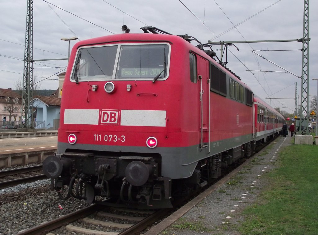 111 073-9 hat am 15. April 2011 soeben mit einem RE aus Nrnberg Hbf den Kronacher Bahnhofauf Gleis 4 erreicht. Man beachte die Zugzielanzeige und den Pantografen (die Lok schiebt).