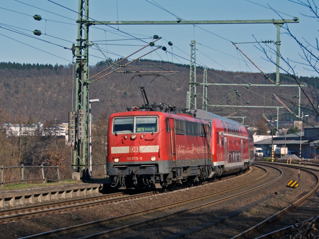 111 075-8 zieht den Rhein-Sieg-Express (RE 9) am 20.03.2011 in Betzdorf-Scheuerfeld von Siegen ber Kln nach Aachen. Die Zge fahren in Doppelbespannung, hinten ist die 111 012 im Einsatz.