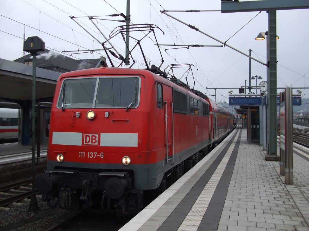 111 137-6 steht mit erhobenen Scherenstromabnehmern und ihrem RE nach Braunschweig in Bielefeld. 15.02.2011.