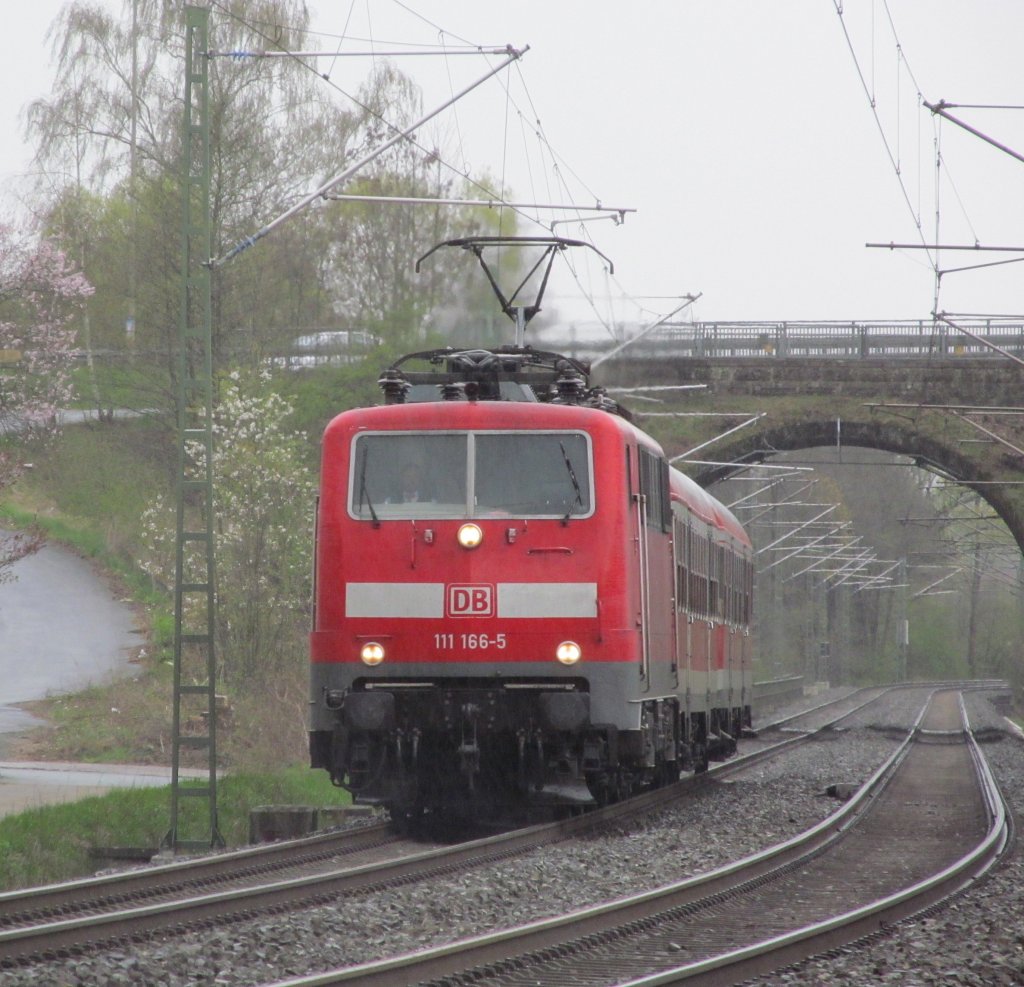 111 166-5 ist am 21. April 2012 mit einer Regionalbahn von Bamberg nach Kronach zwischen Neuses und Kronach unterwegs.
