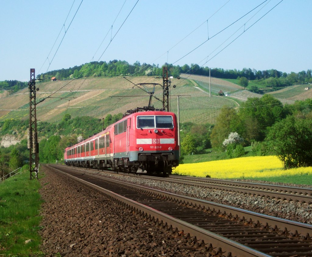 111 221 ist am 23.04.11 mit einem RE nach Frankfurt(M) bei Himmelstadt unterwegs.