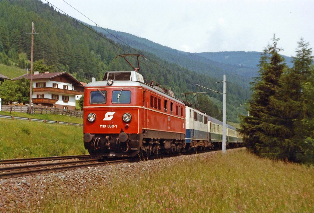 1110.530+DB 111 mit D-489 zwischen Matrei und Stainach am Brenner. Juni 1986