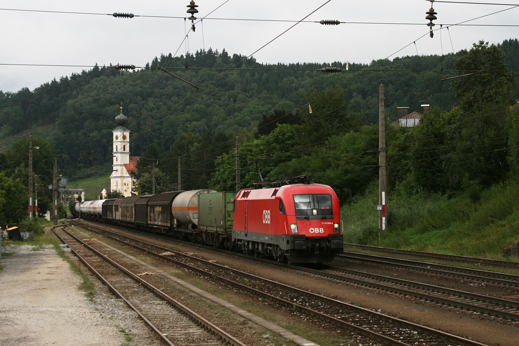 1116 028 mit einem gemischten Gterzug am 13.08.2010 in Wernstein.