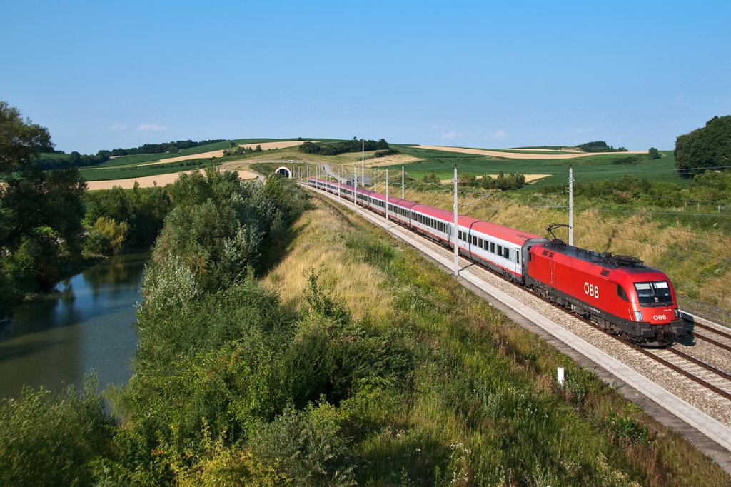 1116 132 ist mit dem OIC 648 von Wien Westbahnhof nach Salzburg unterwegs. Perschling, am frhen Abend des 15.07.2013.